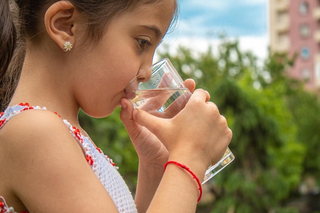 Dziecko pijące czystą wodę w przyrodzie.selectiv fokus