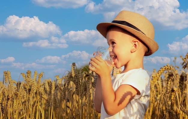Dziecko pije wodę na tle pola
