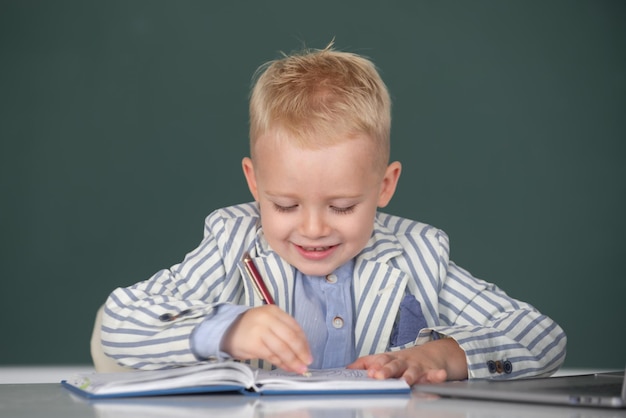 Dziecko pisze w klasie portret śmiesznego ucznia szkoły podstawowej w klasie w szkole