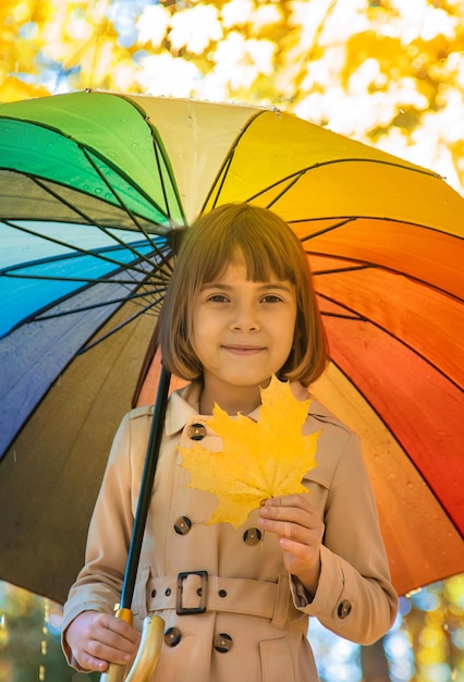 Dziecko pod parasolem w jesiennym parku Selektywne skupienie