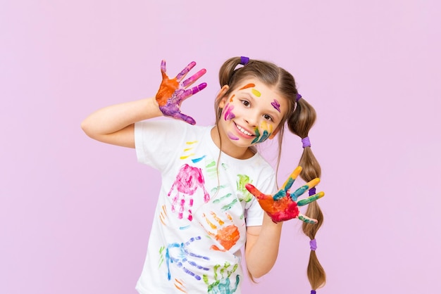 Dziecko poplamione wielobarwnymi farbami będzie musiało być kreatywne Koncepcja kreatywności dzieci na różowym, izolowanym tle
