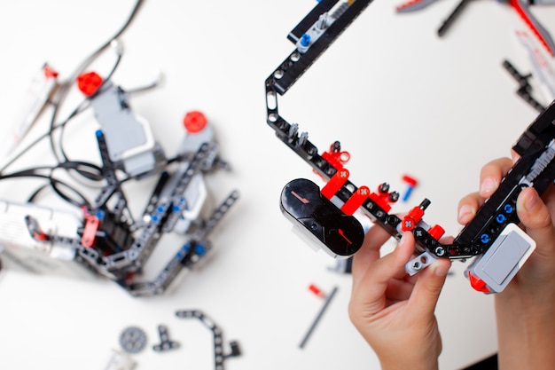 Dziecko robi robota z klockami zabawek i drutami