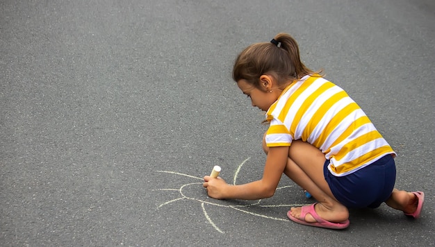 Dziecko rysuje kredą na chodniku serce to słońce Natura