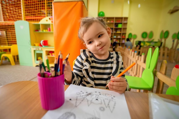 dziecko rysuje ołówkami w pokoju zabaw