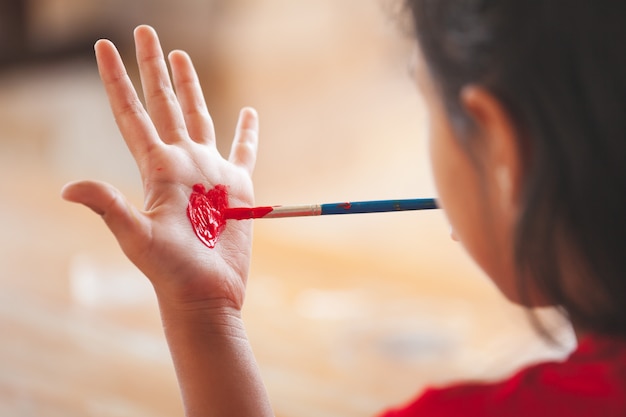 Dziecko Rysuje Serce Na Jej Ręce Z Zabawą I Maluje