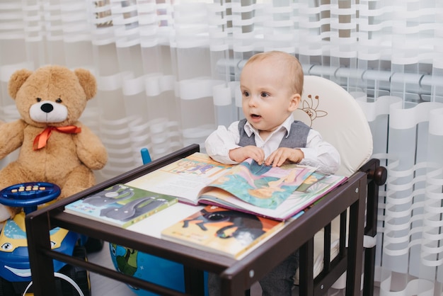 Dziecko siedzi w wysokim krzesełku z książeczką z napisem „Mały Książę”