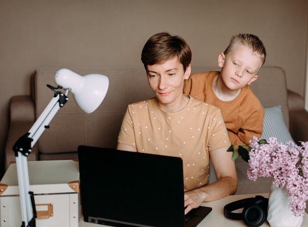 Dziecko syn i mama pracuje w domu laptopa