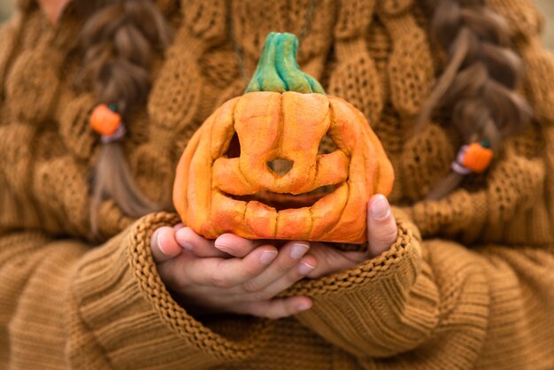 dziecko trzyma małą dynię na Halloween