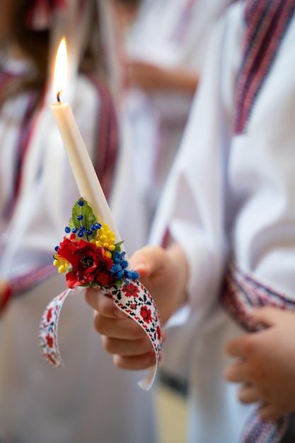 Dziecko trzyma w ręku świecę w kościele podczas nabożeństwa