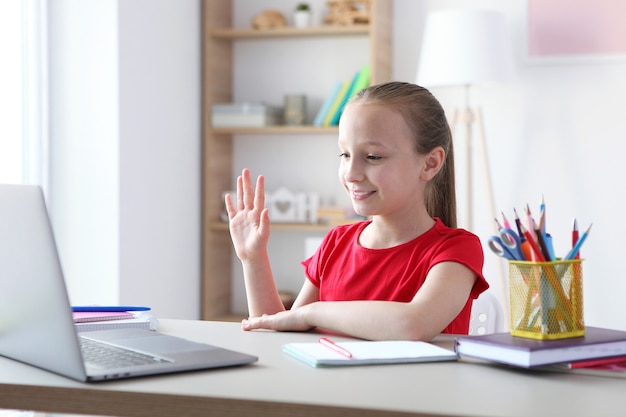 Dziecko uczy się online w domu za pomocą nowoczesnego laptopa w internecie