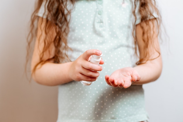 Dziecko używa antybakteryjnego antyseptycznego żelu do dezynfekcji rąk przed bakteriami.