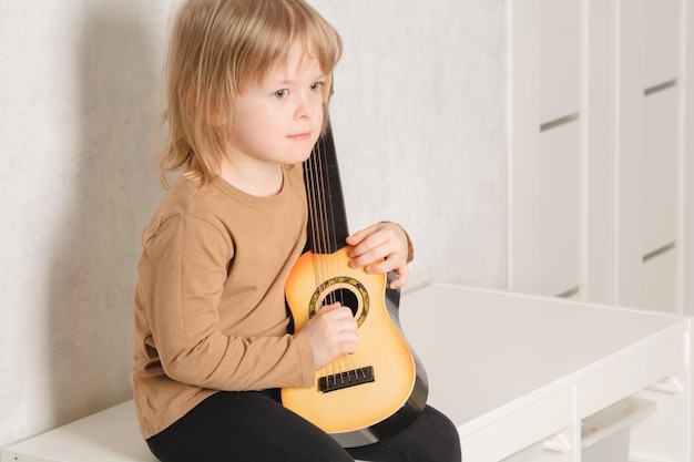 Zdjęcie dziecko w domu uczące się grać na gitarze wolny czas i edukacja w domu