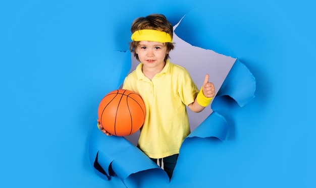 Zdjęcie dziecko w odzieży sportowej z piłką do koszykówki pokazującą aktywny trening koszykówki