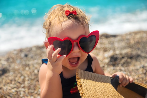 Dziecko w okularach przeciwsłonecznych na plaży. Selektywne skupienie. Dziecko.