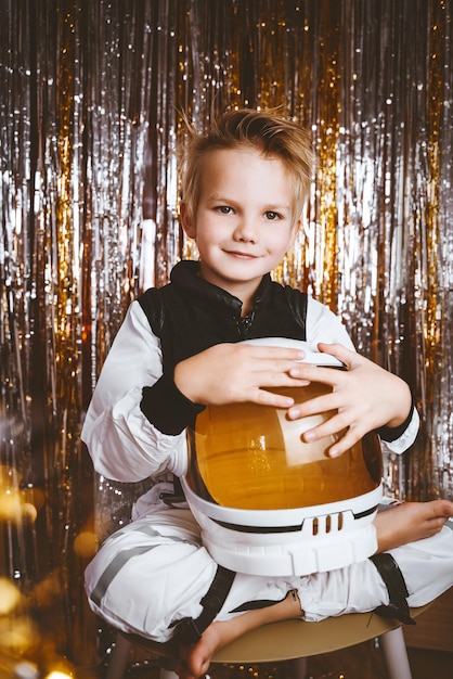 Dziecko w przebraniu kostiumu pilota astronauty bawiące się na balu maskowym w świątecznym tle