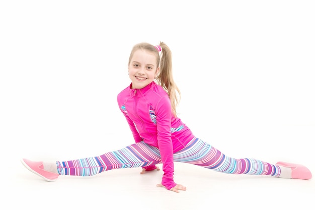 Dziecko w różowej odzieży sportowej. Trening małej dziewczynki na białym tle. Edukacja i energia. Fitness i zdrowie. Sport i sukces., sport