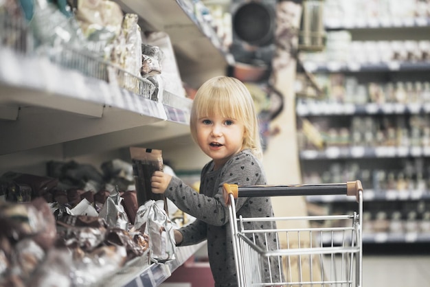 Zdjęcie dziecko w sklepie kupuje jedzenie