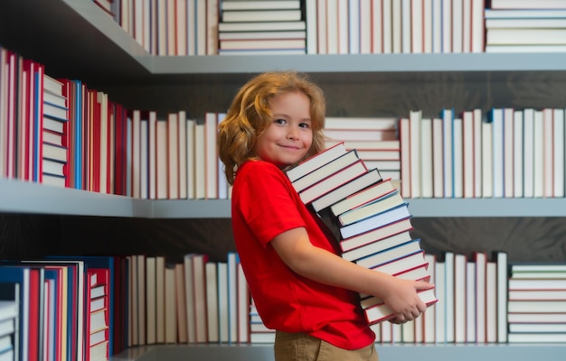 Dziecko w szkole z okazji Dnia Wiedzy ze stosem książek Dzieci lubią historię książek w szkolnej bibliotece dla dzieci obraz