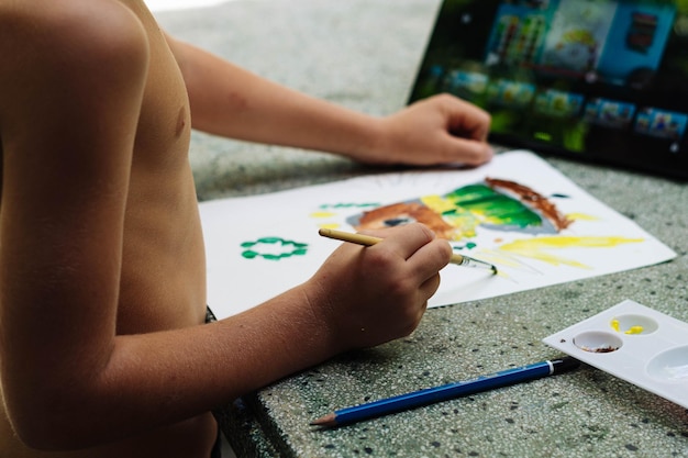 Dziecko w wieku przedszkolnym rysunek obraz żółty zielony jasny brązowy akwarela pędzel ręka ołówek nierozpoznany tylny widok z boku