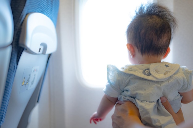 Dziecko wygląda przez okno samolotu