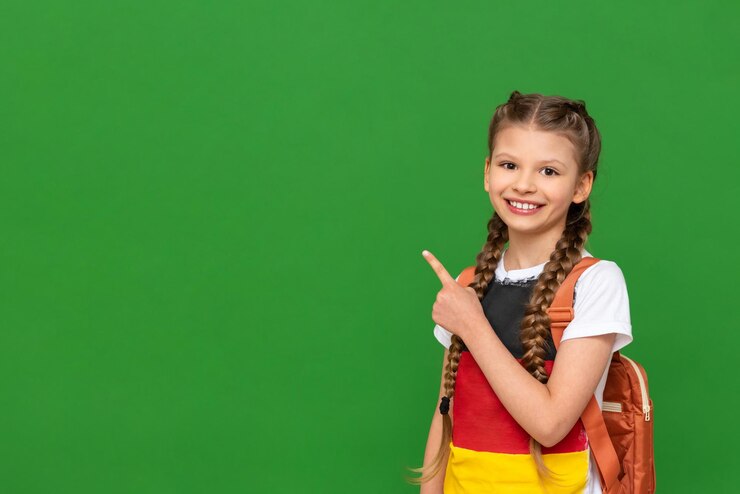 Zdjęcie dziecko z niemiecką flagą na koszulce wskazuje palcem na bok reklamy