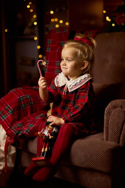 Dziecko z prezentem świątecznym urocza dziewczynka w czerwonej sukience