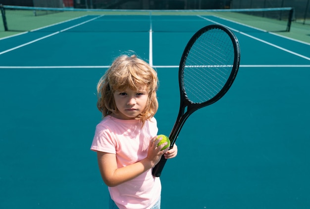 Zdjęcie dziecko z rakietą tenisową i piłką na korcie tenisowym ćwiczenie sportowe na świeżym powietrzu dla dzieci letnich zajęć