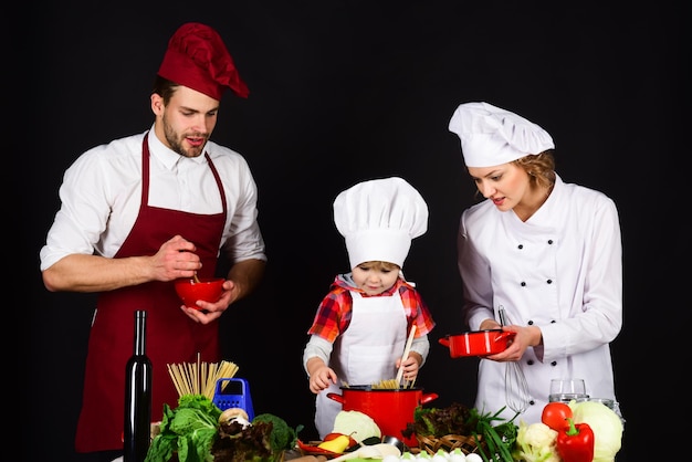 Dziecko z rodzicami przy kuchennym stole gotuje szczęśliwa kochająca rodzina wspólnie przygotowuje obiad