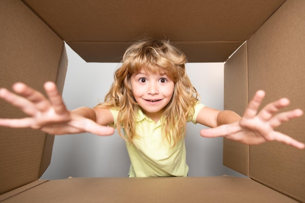 Dziecko zaglądające do kartonu weź ręcznie prezent widok z dołu dostarczając twój zakup dzieci celeb