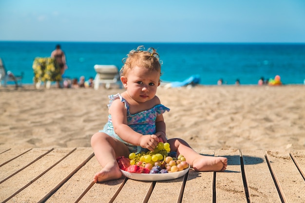 Dziecko zjada owoce nad morzem. Selektywne skupienie. Dziecko.