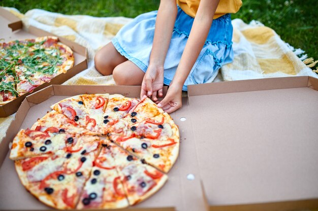 Dzielenie Się Pizzą, Mała Dziewczynka Ręce Biorąc Kawałek Pizzy Z Pudełka Na świeżym Powietrzu, Piknik Rodzinny, Jedzenie Pizzy Na Obiad, Dostawa Fast Foodów.