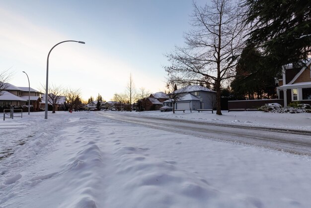 Dzielnica mieszkaniowa na przedmieściach z drogą pokrytą białym śniegiem