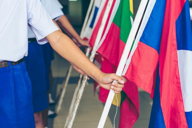 Zdjęcie dzień asean przypada na 8 sierpnia, dłoń trzymająca flagi z tkaniny stowarzyszenia azji południowo-wschodniej