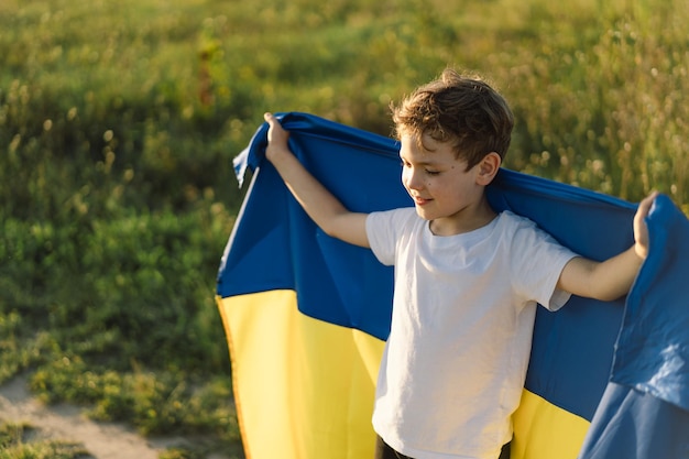 Dzień Niepodległości Ukrainy Ukraiński chłopiec w białej koszulce z żółto-niebieską flagą Ukrainy w polu Flaga Ukrainy Dzień Konstytucji Stoisko z Ukrainą Ocal Ukrainę