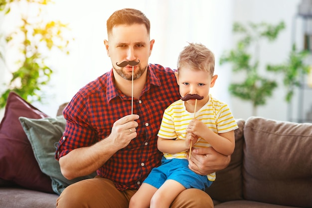 Zdjęcie dzień ojca szczęśliwy zabawny rodzinny syn i tata z wąsami