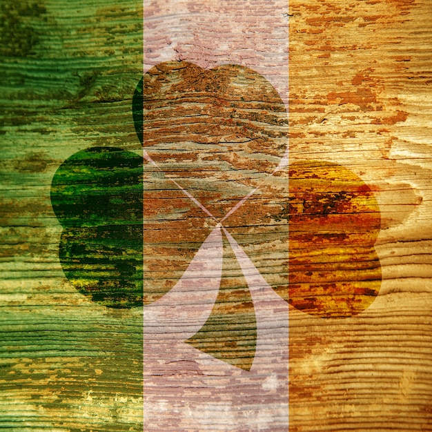 Dzień Św. Patryka Ciemna plama w kształcie koniczynek na drewnianej powierzchni w kolorze irlandzkiej flagi