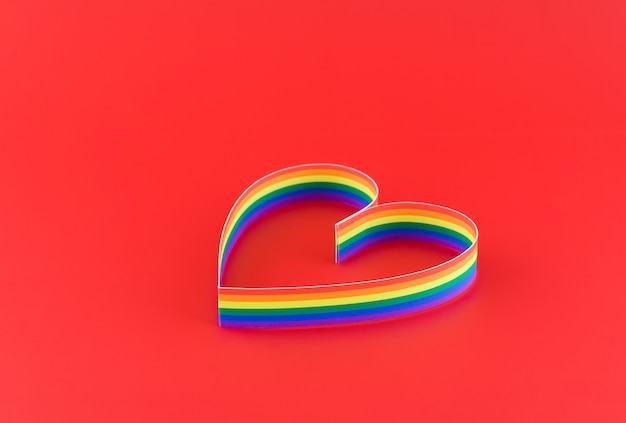 Zdjęcie dzień świętego walentego. pojedyncze serce, farba przedstawiająca sześciokolorową flagę gejów. na czerwonym.