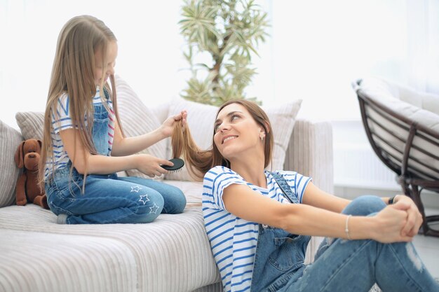 Dzień urody mama bawi się z córeczką w salonie fryzjerskim