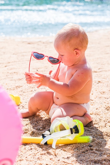 Dziewczyna bawi się na piasku na plaży w słoneczny dzień