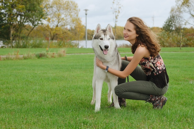 Dziewczyna bawić się z husky psem w miasto parku. Szkolenie psa.