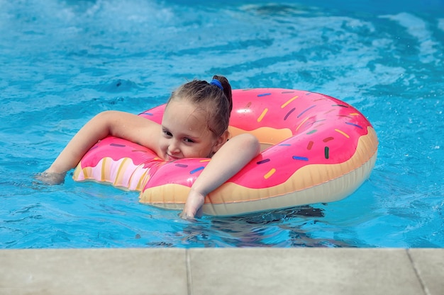 dziewczyna dobrze się bawi i latem aktywnie spędza wakacje w odkrytym basenie w chłodnej wodzie