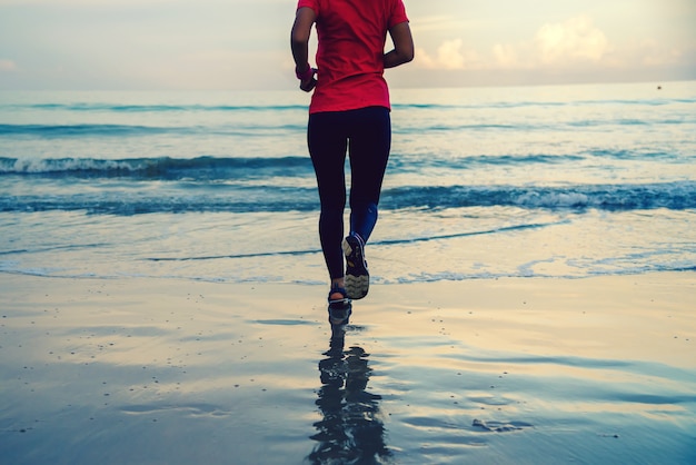 Dziewczyna działa trening jogging na plaży rano.