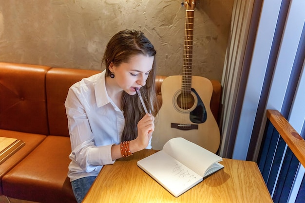 Dziewczyna gra na gitarze w kawiarni