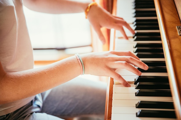 Dziewczyna gra na pianinie w domu pod dużym kątem widzenia rozmyte tło