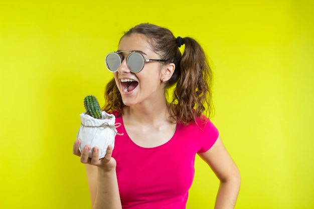 Zdjęcie dziewczyna gryzie kaktusa.