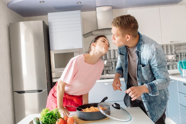 Dziewczyna i chłopak przygotowują razem obiad w kuchni