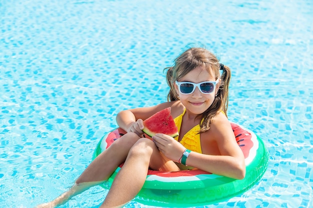 Dziewczyna je arbuza w nadmuchiwanym arbuzie w basenie