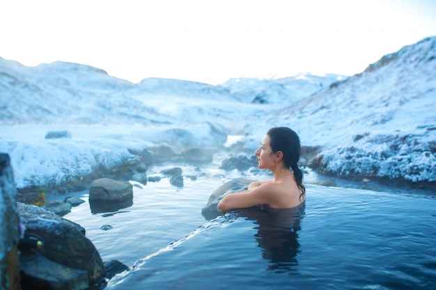 Dziewczyna Kąpie Się W Gorącym źródle Na świeżym Powietrzu Ze Wspaniałym Widokiem Na Zaśnieżone Góry. Niesamowita Islandia W Zimie.