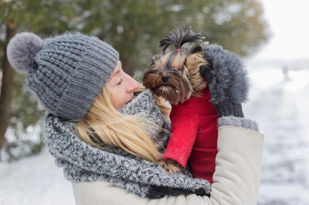 Dziewczyna Ma Zabawę Na Zewnątrz W śniegu Z Psem Yorkshire Terrier.