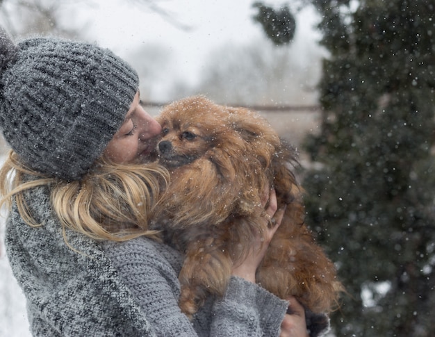 Dziewczyna Ma Zabawę Na Zewnątrz W śniegu Z Psem Yorkshire Terrier.